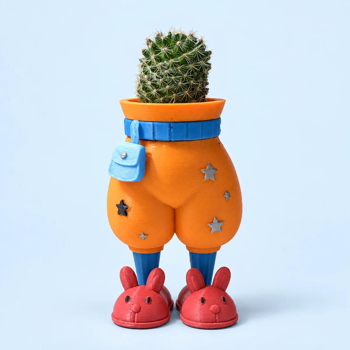 Orange thin pants planter with a blue mini bag and belt, star details, blue shins and red bunny slippers, holding a cactus